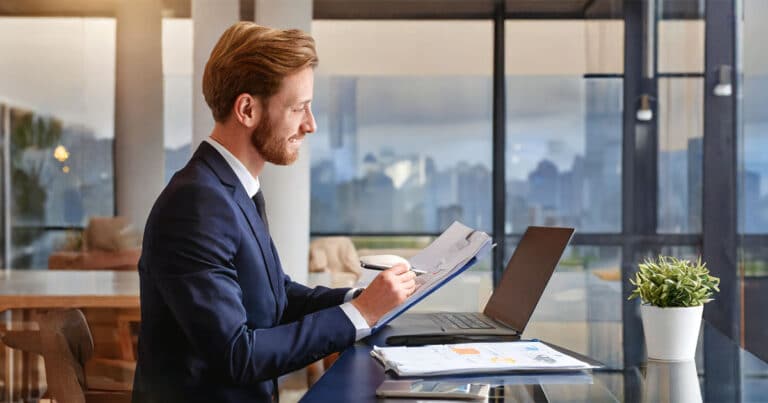 Professional man jotting notes at desk